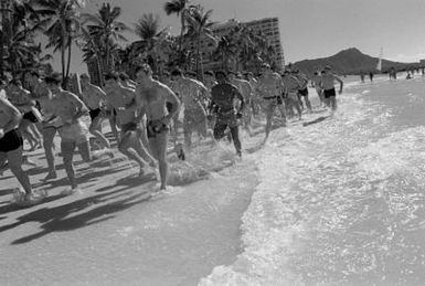 Members of the Air Force Academy football team job on Waikiki Beach before their game with the team from the University of Hawaii