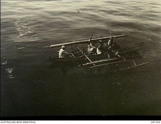 Los Negros Island, Admiralty Group. c. 1943. Five natives in a small outrigger canoe