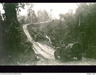 THE SOLOMON ISLANDS, 1945. AUSTRALIAN MANNED JEEP FITTED WITH CHAINS TRAVELLING ALONG THE NUMA NUMA TRAIL ON BOUGAINVILLE ISLAND. (RNZAF OFFICIAL PHOTOGRAPH.)