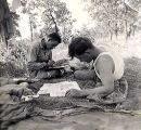 Orville Dodge and Ralph Gaugler writing letter and reading, Guadalcanal, 1940s
