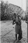 Wanuma: woman holds infant and young cassowary at Lutheran mission