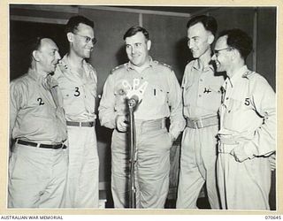 PORT MORESBY, PAPUA 1944-02-26. THE GENERAL MANAGER, AUSTRALIAN BROADCASTING COMMISSION, LIEUTENANT COLONEL C.J.A. MOSES (1) WITH MEMBERS OF THE STAFF OF "9PA", THE AUSTRALIAN BROADCASTING ..