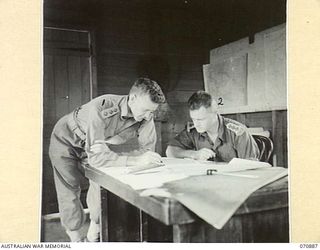 KIANDI, NEW GUINEA, 1944-02-25. P454 CAPTAIN C.W.G. FOX (1), (AFTER WHOM IS NAMED "FOX'S SADDLE", AND FOX'S CAMP IN THE REINHOLD HIGHWAY), WITH NX12187 CAPTAIN M.R. MOORE REPRESENTATIVES OF ..