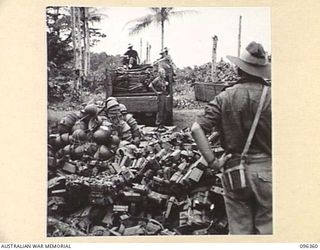 KAIRIRU ISLAND, NEW GUINEA, 1945-09-08. TRUCK LOADED WITH WEAPONS FROM JAPANESE WEAPON DUMP IN FOREGROUND. STAFF OFFICERS OF HQ 6 DIVISION VISITED THE ISLAND TO MAKE ARRANGEMENTS WITH JAPANESE ..