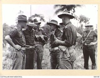 SUAIN PLANTATION, NEW GUINEA. 1944-12-10. MAJOR-GENERAL J.E.S. STEVENS, GENERAL OFFICER COMMANDING 6 DIVISION, (4), CONSIDERING PATROL REPORTS OF THE PLANTATION AREA NEAR THE DANMAP RIVER AND ..