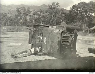 NEW GUINEA. C. 1943. AT AN ADVANCED NEW GUINEA BASE RAAF TRANSPORT PERSONNEL SOLVE THE PROBLEM OF SERVICING A JEEP'S "INNARDS". THERE'S NOT TIME BETWEEN CAMP MOVES TO BUILD A RAMP, SO THE LADS LIE ..