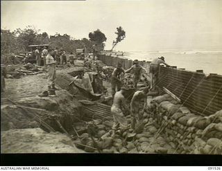 Motupena Point, Bougainville. 1945-05-02. Sappers of 5 Field Company, Royal Australian Engineers, constructing a sea wall of sheet iron and sandbags to protect the Motupena Point - Toko Road which ..