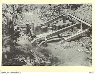 BOUGAINVILLE ISLAND. 1945-02-13. AN AUSTRALIAN ARMY BULLDOZER BADLY BOGGED IN A SECTION OF THE KUPON- MOSIGETTA BUIN ROAD WHILE CARRYING OUT REPAIRS TO ROAD TO FACILITATE TRANSPOTING SUPPLIES TO ..