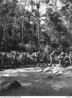 FARIA RIVER, NEW GUINEA, 1944-02-15. MEMBERS OF 15TH PLATOON, "C" COMPANY, 57TH/60TH INFANTRY BATTALION CROSSING THE JUNCTION OF MAINSTREAM AND THE FARIA RIVER AS THEY MOVE WITH THE 15TH INFANTRY ..