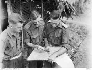 YAMIL 2, NEW GUINEA. 1945-08-01. LIEUTENANT COLONEL F.G. WOOD, COMMANDING OFFICER, 2/6 INFANTRY BATTALION (2), DISCUSSING OPERATIONS AND MOVEMENTS ON THE MAP WITH CAPTAIN J.C. WALKER, ADJUTANT (1) ..
