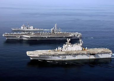 (From bottom-to-top), Aerial port view of the U.S. Navy Tarawa Class Amphibious Assault Ship USS SAIPAN (LHA 2), the Nimitz Class Aircraft Carrier USS DWIGHT D. EISENHOWER (CVN 69), and the Ticonderoga Class Guided Missile Cruiser USS ANZIO (CG 68), as they sail in formation during a photographic exercise on Nov. 20, 2006. The ships are currently deployed in support of maritime security operations in the Arabian Sea. (U.S. Navy photo by Mass Communication SPECIALIST SEAMAN Patrick W. Mullen III) (Released)