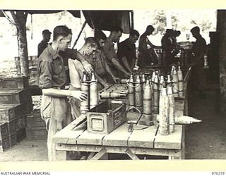 PORT MORESBY, NEW GUINEA. 1944-02-02. VX143504 PRIVATE E. KEENAN (1) REPAIRING A 25 POUNDER HIGH EXPLOSIVE SHELL AT THE 6TH MOBILE AMMUNITION REPAIR SHOP IN THE 8TH ADVANCED AMMUNITION DEPOT. ..