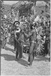 Pig festival, singsing, Kwiop: decorated host presents netbag of food to decorated man from visiting phratry