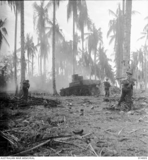 AUSTRALIAN MANNED GENERAL STUART M3 TANKS BUST JAPANESE PILLBOXES IN THE FINAL ASSAULT ON BUNA. MEN OF D COMPANY, 2/12TH BATTALION, SHOOT JAPANESE FLEEING FROM A TANK BLASTED PILLBOX. SMOKE AT LEFT ..