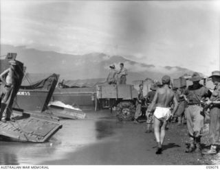 LAE, NEW GUINEA. 1943-10-17. TROOPS OF THE 29/46TH AUSTRALIAN INFANTRY BATTALION LOADING THEIR BARGES ON THE BEACH WITH PROVISIONS IN THE TRUCKS. NOTE THE BARGE IN THE CENTRE NAMED "THE DUCHESS". ..