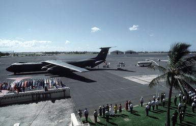 Military personnel and spectators watch as the remains of 27 service members missing in action are carried from a C-141B Starlifter aircraft. The service members were returned in the largest turnover of MIAs since meetings began with North Vietnam in 198