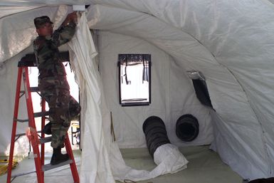 U.S. Air Force STAFF SGT. Edward Mendiola from Guam, deplyed to the 3rd Air Expeditionary Group at Kwang-Ju Air Base, Republic of Korea, installs the air duct for the medical services Small Shelter System on Sept. 3, 2004. (U.S. Air Force photo by Technical Sergeant Corey A. Clements) (Released)