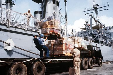 Pallets of books for local schools are unloaded from the tank landing ship USS RACINE (LST 1191) as part of a civic action project