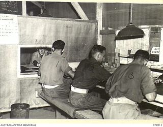 LAE, NEW GUINEA. 1945-02-06. PERSONNEL OF THE 119TH LINES OF COMMUNICATION SIGNALS. HEADQUARTERS, FIRST AUSTRALIAN ARMY WORKING IN THE UNIT SIGNALS OFFICE CERTIFYING AND CHECKING SIGNALS BEFORE ..