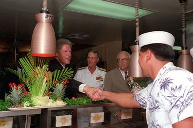 President William Jefferson Clinton chats while in the serving line in the enlisted galley during a tour of area military installations