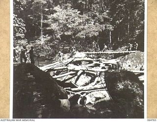 UBERI AREA, NEW GUINEA. 1943-12-19. A PARTY FROM THE CHAUVEL ENTERPRISES LTD., A FILM MAKING COMPANY, PROCEEDING TO UBERI ACROSS A TEMPORARY BRIDGE TO TAKE THE FINAL SEQUENCES OF THE "RATS OF ..