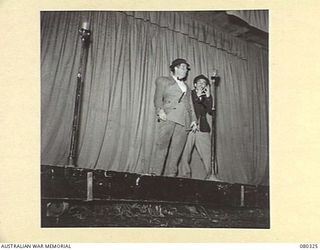 LAE, NEW GUINEA. 1944-07-25. A HILARIOUS INTERLUDE BETWEEN TWO COMEDIANS DURING THE 3RD ARMOURED DIVISION CONCERT PARTY, AUSTRALIAN ARMY AMENITIES SERVICE PRODUCTION OF "SHELLS-A-POPPIN". ..