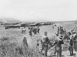 KAIAPIT, NEW GUINEA. 1943-09-20. TROOPS OF THE 2/16TH BATTALION, 21ST AUSTRALIAN INFANTRY BRIGADE ARRIVING AT KAIAPIT. TRANSPORT AIRCRAFT CAN BE SEEN IN THE BACKGROUND