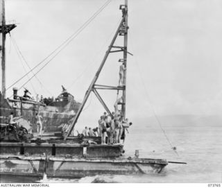 LAE, NEW GUINEA. 1944-06-08. COMPETITORS IN THE 50 YARDS SWIM APPROACH A FLOATING PILE DRIVER WHICH WAS USED AS A STARTING POINT BY MEMBERS OF THE 2/7TH ADVANCED WORKSHOP DURING SWIMMING EVENTS IN ..