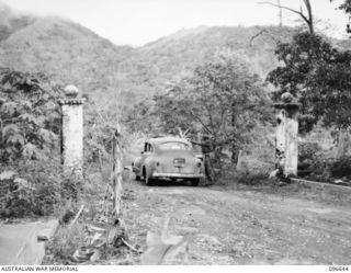 RABAUL, NEW BRITAIN. 1945-09-14. ENTRANCE PILLARS TO THE FORMER GOVERNMENT HOUSE AT RABAUL, WITH A FORMER JAPANESE STAFF CAR ON THE DRIVE. FOLLOWING THE SURRENDER OF THE JAPANESE, HEADQUARTERS 11 ..