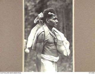 YAULA, NEW GUINEA. 1944-04-11. BEI BEI, A MADANG BOY, CARRYING FOOD TO THE FRONT LINE AT AIYAU DURING THE ADVANCE OF THE 57/60TH INFANTRY BATTALION TO BOGADJIM