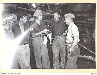 TOROKINA, BOUGAINVILLE, 1945-08-14. THE COMMANDER OF AN M24 LIGHT TANK, CORPORAL L.B. KELLY GIVES MAINTENANCE ORDERS TO HIS CREW DURING ACTIVITIES OF THE BRITISH WAR OFFICE TRIALS TEAM (TANKS)