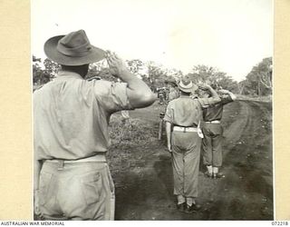 GUSIKA, NEW GUINEA. 1944-04-09. OFFICERS OF THE 2/4TH LIGHT ANTI-AIRCRAFT REGIMENT SALUTING DURING THE SOUNDING OF THE "LAST POST" AT A MEMORIAL SERVICE TO HONOUR MEMBERS KILLED IN THE FINSCHHAFEN ..