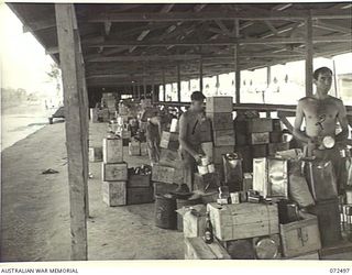 PORT MORESBY, NEW GUINEA. 1944-04-21. MEMBERS OF THE DETAILS ISSUE DEPOT, AUSTRALIAN ARMY SERVICE CORPS, "BREAKING UP" BULK RATIONS INTO LOTS OF UNIT DISTRIBUTION. THE DEPOT IS SITUATED 4 MILES ..