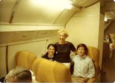 Woman posing with two people on a plane