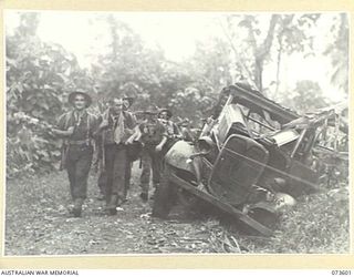 UMAI RIVER, NEW GUINEA. 1944-05-27. TROOPS OF THE 35TH INFANTRY BATTALION PASS AN ABANDONED JAPANESE ARMY TRUCK ON THE TRACK NEAR THE RIVER DURING THEIR ADVANCE ALONG THE COAST TOWARDS WEWAK. ..