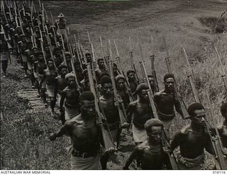 New Guinea. 1943. Members of the Royal Papuan Constabulary march in formation in full fighting kit