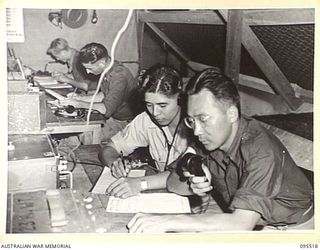 PALMALMAL, JACQUINOT BAY, NEW BRITAIN, 1945-08-24. SERGEANT G.M. OTA (1) AND SERGEANT M.J. FUJIKAWA (2), UNITED STATES MEMBERS OF LANGUAGE DETACHMENT SENDING SIGNALS FROM HEADQUARTERS 11 DIVISION ..