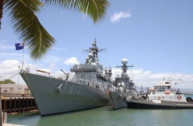 Starboard bow view showing the Republic of Korea (KOR) Navy, KWANGGAETO THE GREAT (KDX-1) CLASS; Destroyer, YANMANCHOON (DDH 973) and the KOR Navy PO HANG CLASS: Corvette, WONJU (FS 769), being assisted by a commercial tugboat while conducting side-by-side pier side mooring operation, after arriving at Naval Station Pearl Harbor, Hawaii (HI), to participate in Exercise RIMPAC 2002