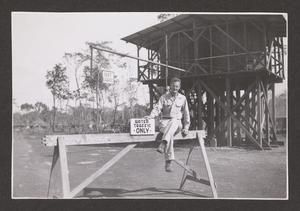 [Henry J. Cates, Jr., Sitting on Sign]
