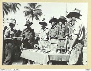 MILILAT, NEW GUINEA. 1944-08-13. VX150 LIEUTENANT-COLONEL W.N. LING, COMMANDING OFFICER, 5TH DIVISION SIGNALS (1) CONGRATULATING PRIZE WINNERS AT THE UNIT HOBBIES COMPETITION AND EXHIBITION AT THE ..