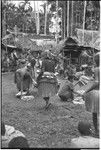 Mortuary ceremony, Omarakana: mourning women count banana leaf bundles for ritual exchange, woman in center wears decorated fiber skirt