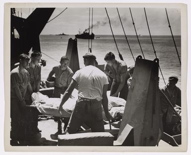 Photograph of Men Moving a Body on Deck of Ship