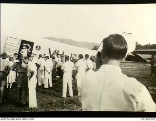 Salamaua, New Guinea. 1941-12. A crowd of men stand on the airfield watching women and children board the tri-motor Junkers 31 aircraft VH-UOV owned by Bulol Gold Dredging Ltd. This aircraft ..