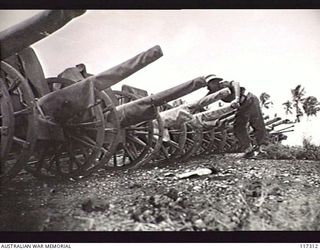 NAURU ISLAND. 1945-09-16. A MEMBER OF THE 31/51ST INFANTRY BATTALION EXAMINING A JAPANESE GUN CAPTURED BY MEMBERS OF THE UNIT SOON AFTER THEY HAD OCCUPIED THE ISLAND