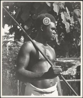 Asavia [?] with a spear over his shoulder and a kapkap in his hair, Rabaul, New Guinea, ca. 1936 / Sarah Chinnery