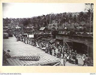 THE WHARF, JACQUINOT BAY, NEW BRITAIN, 1945-08-13. HEADQUARTERS 5 DIVISION AND ATTACHED TROOPS ON THE WHARF IN THE PROCESS OF EMBARKING ABOARD THE TROOPSHIP VAN OUTHOORN FOR THEIR RETURN TO ..