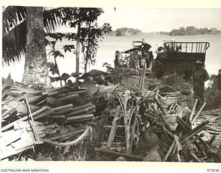 MADANG, NEW GUINEA. 1944-04-28. AN AUSTRALIAN ARMY MLC (MILITARY LANDING CRAFT), AT THE SHORE NEAR MATUPI TO LOAD ABANDONED JAPANESE ENGINEERING STORES, TOOLS AND INSTRUMENTS IN THE AREA NOW ..
