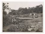 Woman and Ernie Britten standing next to a Japanese heavy artillery, Rabaul, Sep 1949