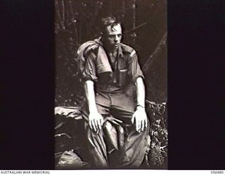 REINHOLD HIGHWAY, NEW GUINEA, 1943-08-31. VX38201 WARRANT OFFICER 2 R. B. IRVING, MILITARY HISTORY PHOTOGRAPHER, MILITARY HISTORY SECTION, HAVING A REST DURING THE DESCENT FROM FOX'S GAP TO CENTRE ..
