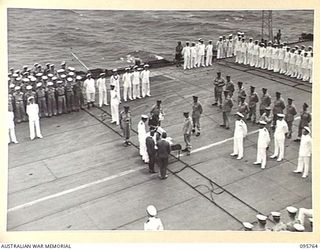 AT SEA OFF RABAUL, NEW BRITAIN. 1945-09-06. THE SURRENDER CEREMONY ON BOARD THE AIRCRAFT CARRIER HMS GLORY, SHOWING VICE ADMIRAL J. KUSAKA, COMMANDERS SOUTH EAST AREA FLEET, SIGNING THE INSTRUMENT ..